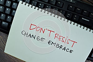Dont`t Resist Change Embrace write on a book isolated on Wooden Table