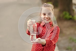 Dont wait, hydrate. Bottle of potable water selective focus. Little girl drinking water to quench thirst. Thirsty child