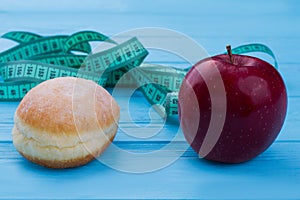 Donut, apple and measuring tape.