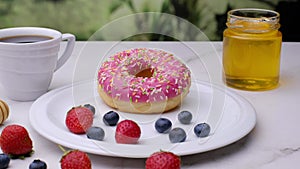 Donut with berries, strawberries. Close-up video shooting, dark background