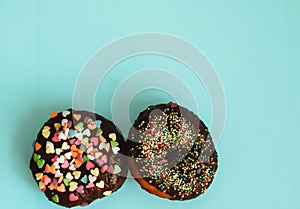 Donut in chocolate glaze with sprinkles in the shape of hearts. Delicious and high-calorie Breakfast.