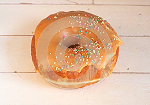 Donut covered in caramel icing and sprinkles