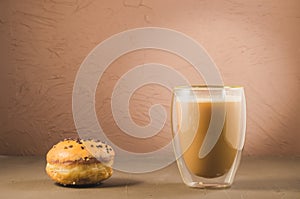 donut in glaze and a cappuccino glass /donut in glaze and a cappuccino glass on a brown background