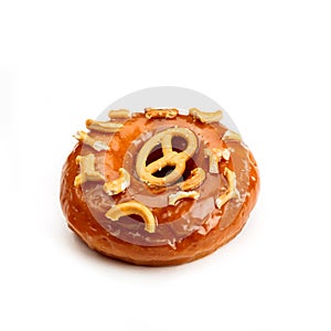 Donut glazed with caramel and pieces of pretzel, isolated on white background. Viewing forty-five degrees