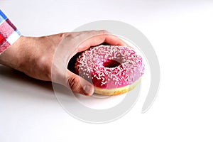 Donut in man`s hand isolated on white background.Top view.