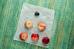 Donut Peaches also known as Saturn peaches, plum and nectarine on a rustic background. Healthy food concept.