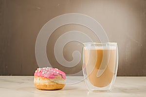 donut in red glaze and a cappuccino/donut in red glaze and cappuccino on a dark background with copy space