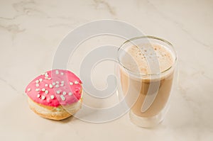 donut in red glaze and a cappuccino /donut in red glaze and cappuccino on a white background, selective focus