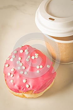 Donut in red glaze and a paper coffee cup/donut in red glaze and