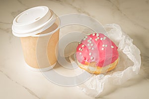 Donut in red glaze and a paper coffee cupdonut in red glaze and