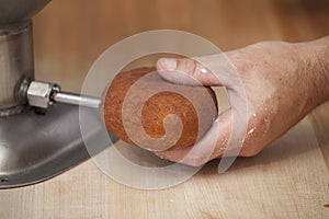 A donut shell being filled with Jelly