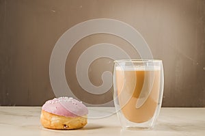 donut in violet glaze and a cappuccino glass /donut in violet glaze and a cappuccino glass. Selective focus