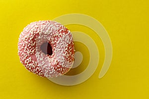 Donut on yellow background. Top view. Copy space.