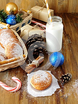 Donuts berliner and a glass of milk surrounded by Christmas attributes