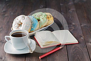 Donuts and coffee, open notebook