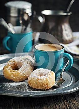 Donuts and cup of coffee on wooden table