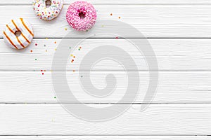 Donuts of different flavors for breakfast on white wooden background top view space for text