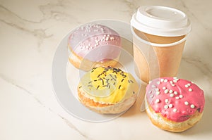 donuts in glaze and a paper coffee cup/donuts in glaze and a paper coffee cup on a white marble background