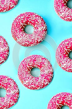 Donuts with icing on pastel pink background