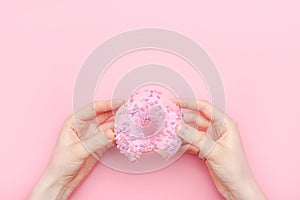 Donuts with icing on pastel pink background. Sweet donuts