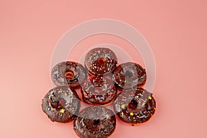 Donuts with icing on pastel pink background. Sweet donuts