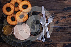 Donuts and jam with coffee cup on wooden table