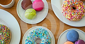 Donuts and macarons on wood, close up view with details