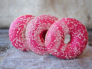 Donuts with pink frosting on the table