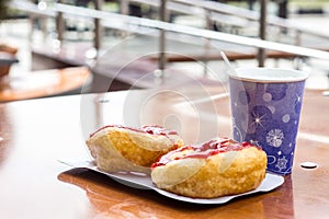 Donuts whith jam on paper plate and coffee