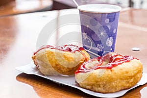 Donuts whith jam on paper plate and coffee