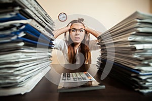 Doomed accountant against big stacks of documents