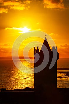 Doonagore Castle silhouette against the setting sun in Doolin, Co. Clare. Ireland