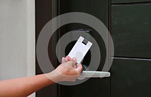 Door access control - young woman holding a key card to lock and unlock door