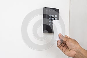 Door access control - young woman holding a key card to lock and unlock door., Keycard touch the security system to access the doo photo