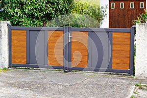 Door aluminum grey and wooden brown gate portal of suburb house