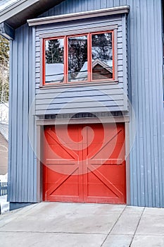 Door of an attached single car garage of home with gray exterior wall siding