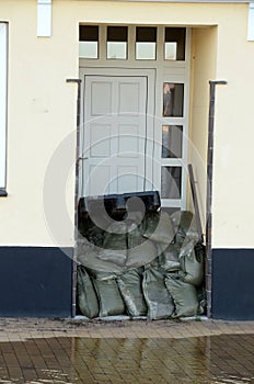 A door blocked with sandbags due to an approaching storm surge, the water stands close to the door