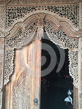Door with calligraphy carving made of jati wood photo