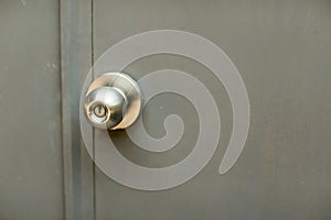 Door with grill, stainless door knob or handle on wooden door in beautiful lighting.