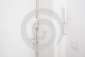 Door handle , bar lock and interphone system on white apartment photo