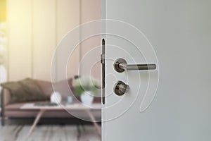 Door handle , door open in front of blur interior room background.