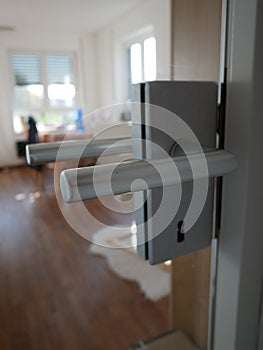 Door handle, glass door and blurred living room background - stay at home