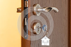 Door handle with inserted key in the keyhole and house icon on it