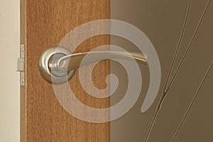 door handle and keyhole on wooden door with glass, close up image