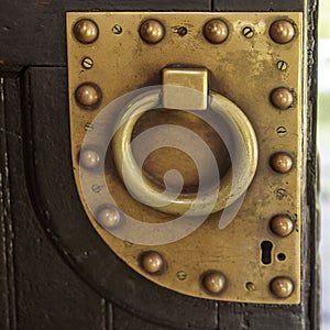 Door handle knocker selective focus on brown old wooden church entrance door front view with copyspace