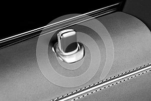 Door handle with lock control buttons of a luxury passenger car. Red leather interior of the luxury modern car. Modern car interio