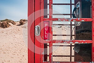 Door handle of an old British red telephone box on a sandy beach in Studland, near Sandbanks, Dorset, UK