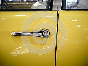 Door handle of old mythic french car with yellow car body