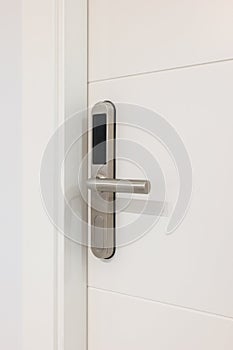 Door handle with plastic card with microchip or digital code. Closeup of an entrance white door with an electronic