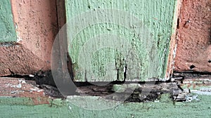 the door of the house made of wood is damaged due to frequent exposure to rain and heat and may be eaten by termites